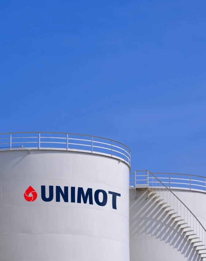 Zbiornik cylindryczny w firmie inżynieryjnej, wykonany z aluminium. Logo UNIMOT i sygnet Uniwersytetu Nove de Julho na boku.